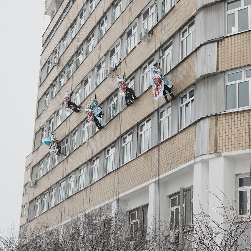 Добровольцы-спасатели спустились с крыши здания в костюмах Дедов Морозов и Снегурочек